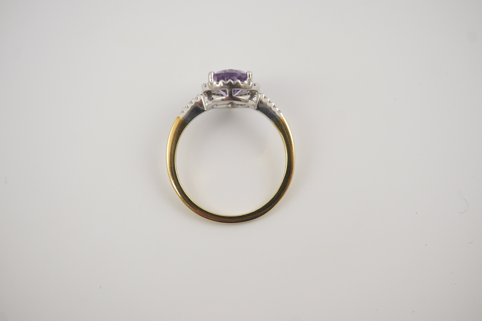 A modern 18ct gold and single stone pear cut amethyst set ring, with diamond chip set border and shoulders